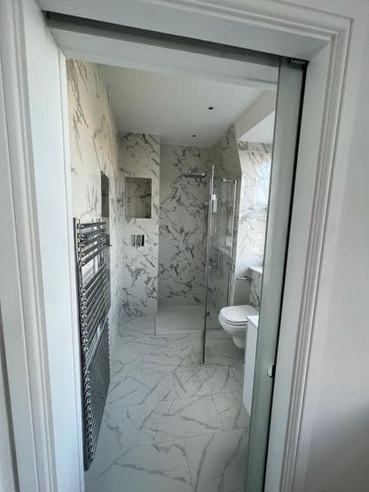 Compact bathroom renovation with walk-in shower and marble-effect tiling